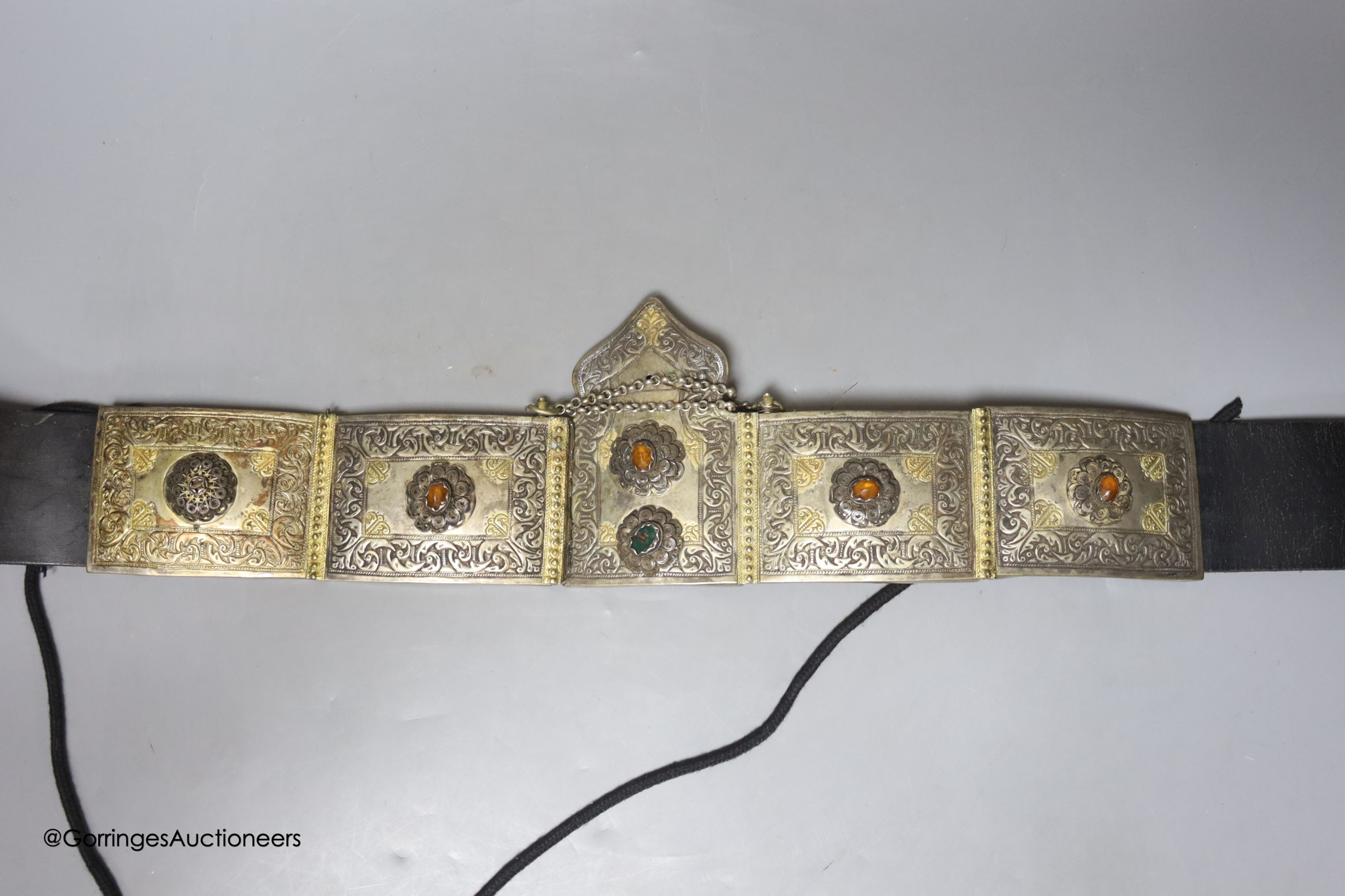 An unusual Eastern white metal and jewelled leather belt, length 80cm